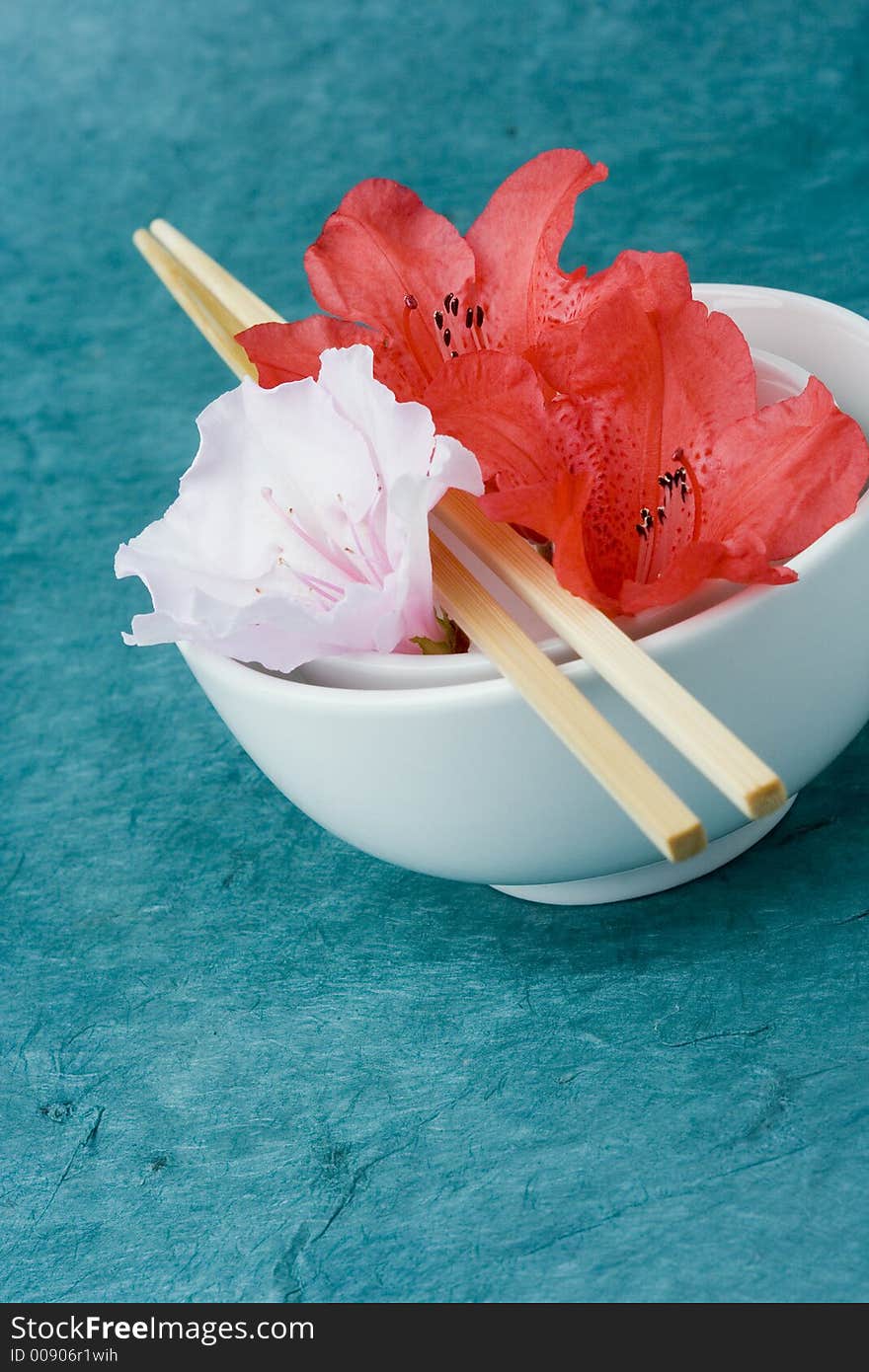 Azaleas or Rhododendron flowers positioned in two rice bowls with chop sticks. Conceptual representation of presentation, styling, food and freshness. Azaleas or Rhododendron flowers positioned in two rice bowls with chop sticks. Conceptual representation of presentation, styling, food and freshness.