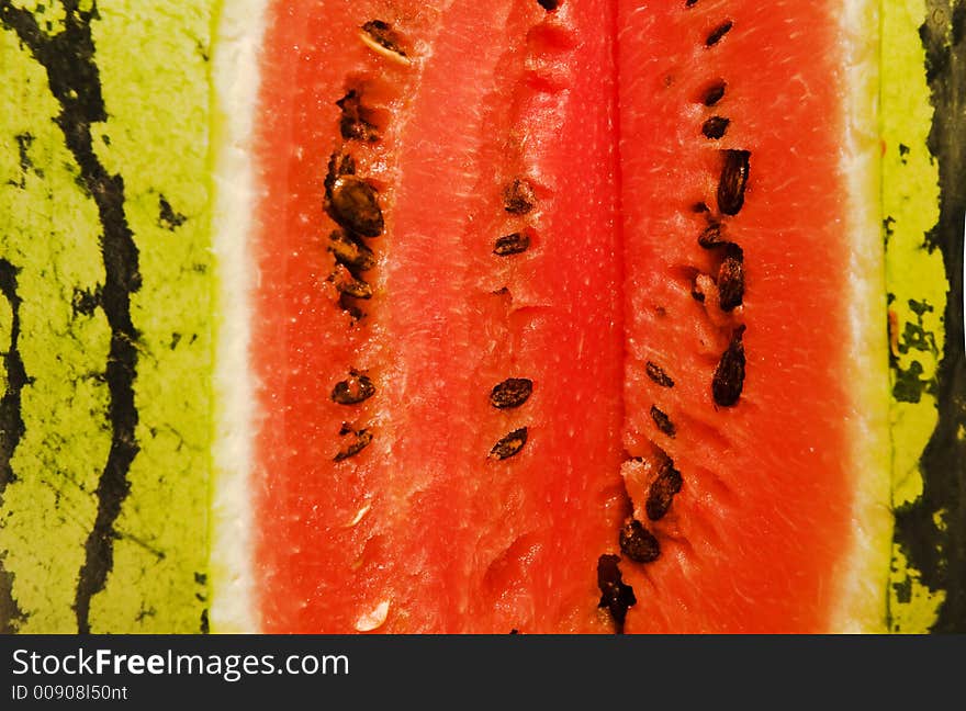 A bright red-green water-melon close-up. A bright red-green water-melon close-up