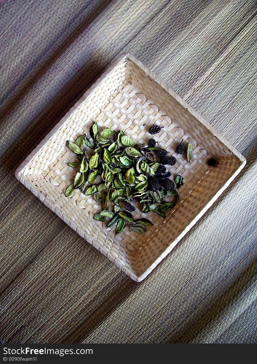 An square basket made from natural fibres over a rush carpet. An square basket made from natural fibres over a rush carpet