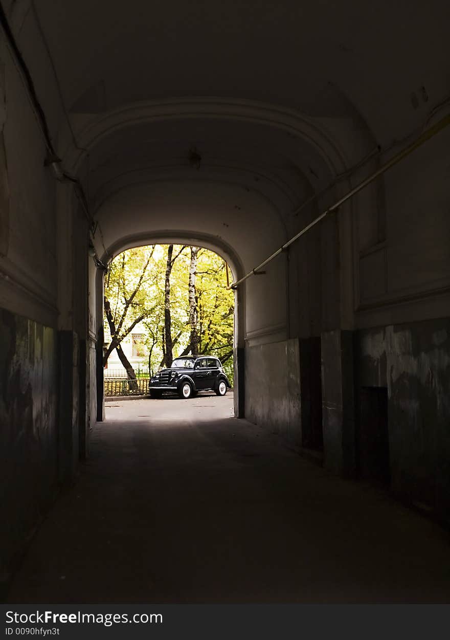 The old automobile stopped opposite to an arch