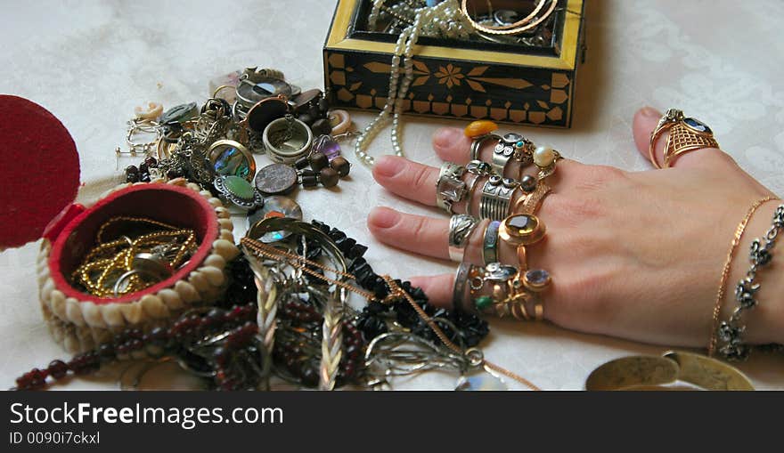 Jeweller ornaments on a table and on a hand. Jeweller ornaments on a table and on a hand