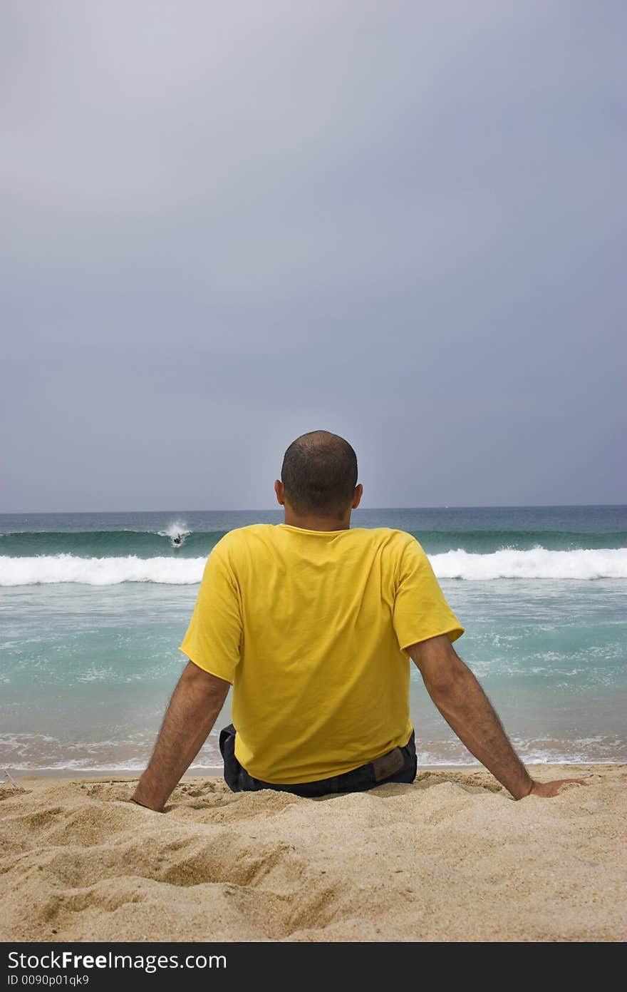 Man on the beach looking the waves