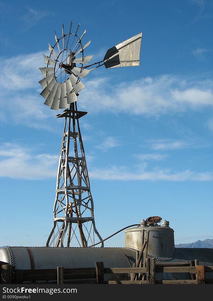 A windmill made out of old car frames pumps water into an old railroad tank car for storage. A windmill made out of old car frames pumps water into an old railroad tank car for storage.