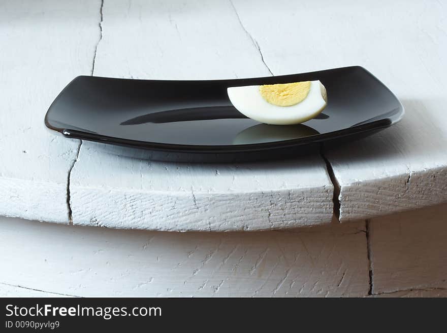 Sliced egg on a black plate. Sliced egg on a black plate