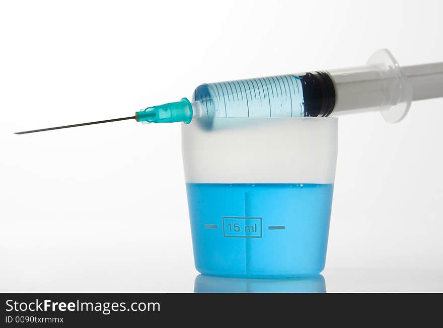 Syringe and medicin blue liquid with reflection