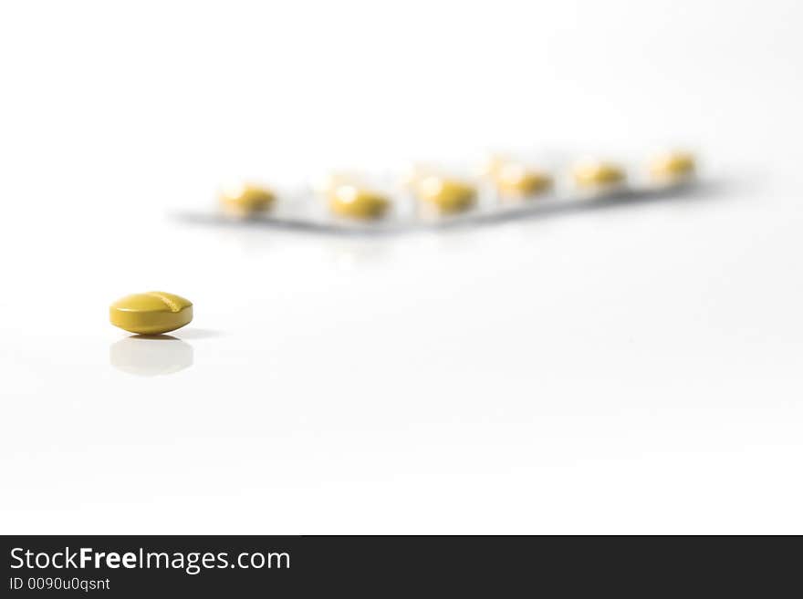 Yellow pill isolated on a white beackground. Yellow pill isolated on a white beackground