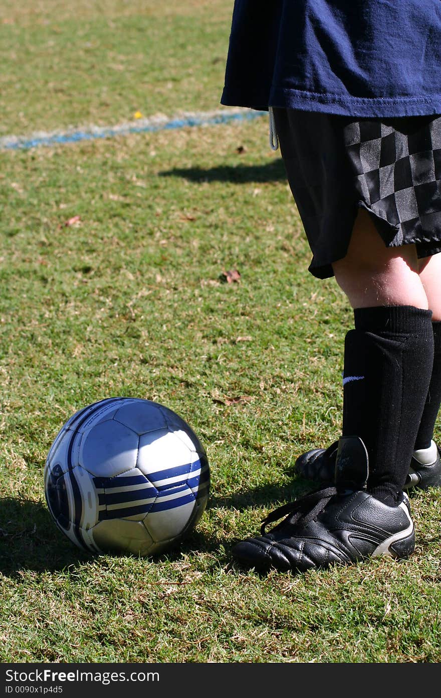 Young boy's legs with soccer cleats, shinguards, and ball. Young boy's legs with soccer cleats, shinguards, and ball