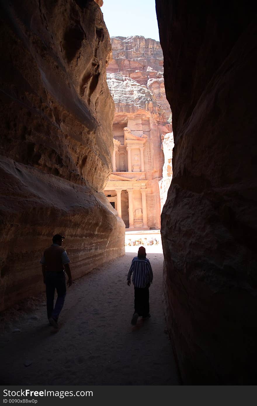 The ancient deserted city of Petra, Jordan, with the Treasury coming into view between the edges of the gorge. The ancient deserted city of Petra, Jordan, with the Treasury coming into view between the edges of the gorge