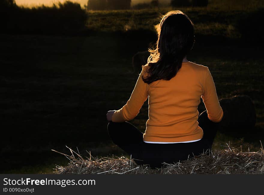 Woman seated in a hay bale. Woman seated in a hay bale