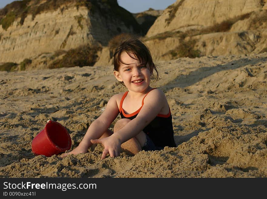 Young Girl at the Beach Playing in the Sand