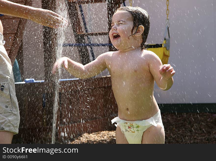 Young Child Getting Wet in Sprinkler. Young Child Getting Wet in Sprinkler