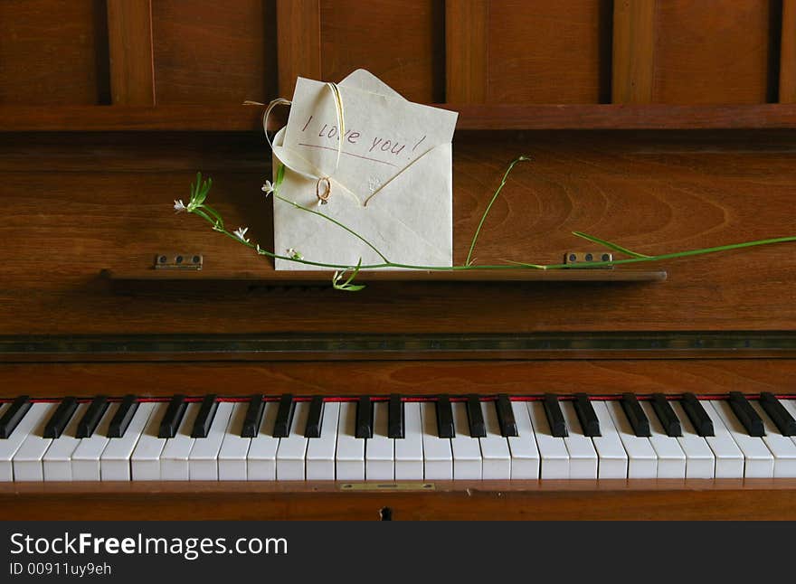 On the piano the envelope with a recognition in love and ring lays