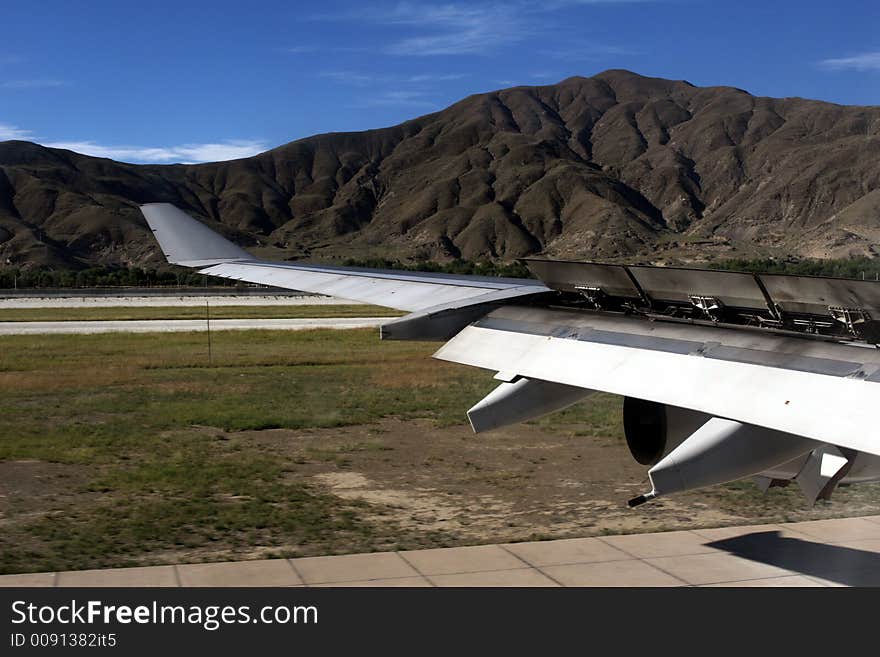 Wing of a landing and slowing down airplane at airport.