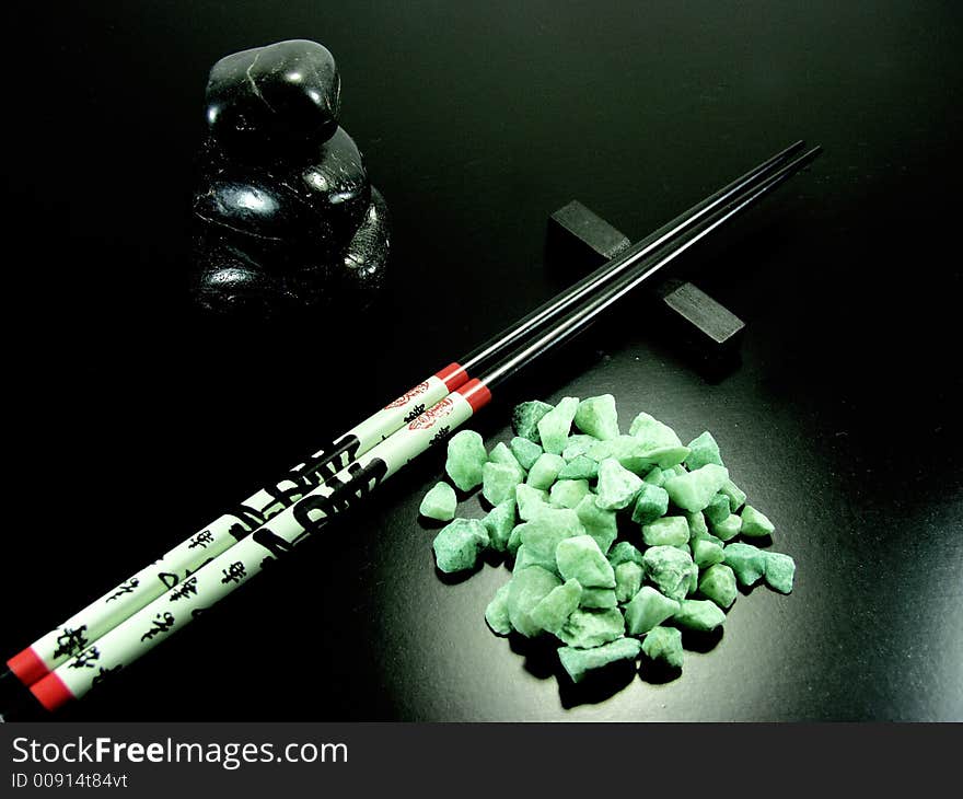 Hot black stones and chopstick whit green stones. Hot black stones and chopstick whit green stones