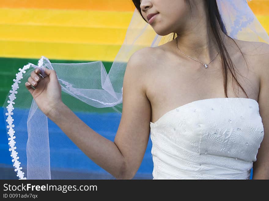 An asian wedding bride posing in the park.