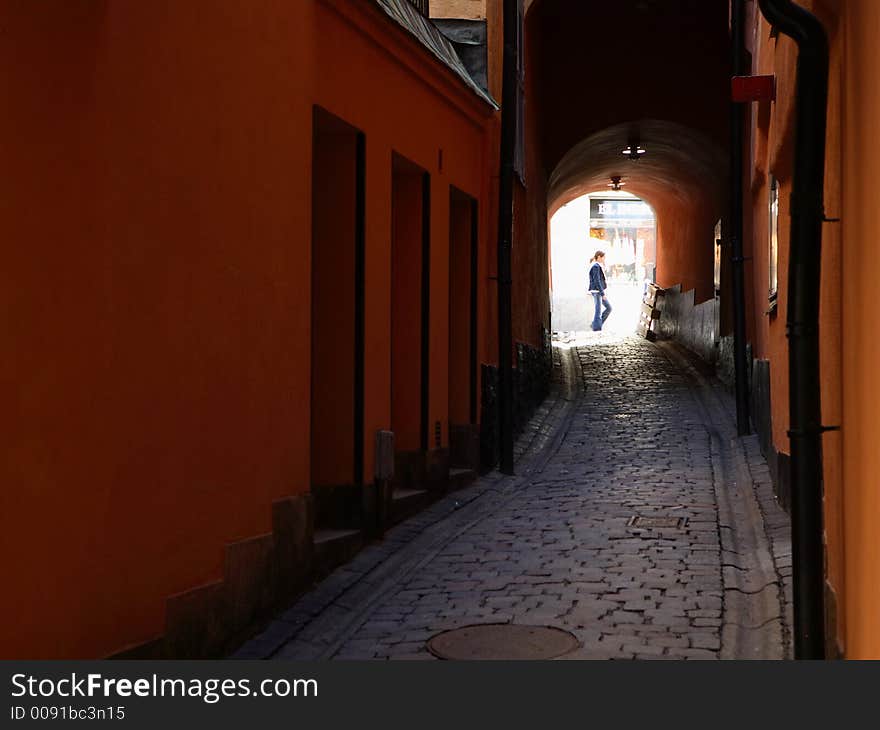 An Alley in Gamla Stan, the old Medieval part of Stockholm, Sweden, on a beautiful day, with a young girl in the background. An Alley in Gamla Stan, the old Medieval part of Stockholm, Sweden, on a beautiful day, with a young girl in the background.