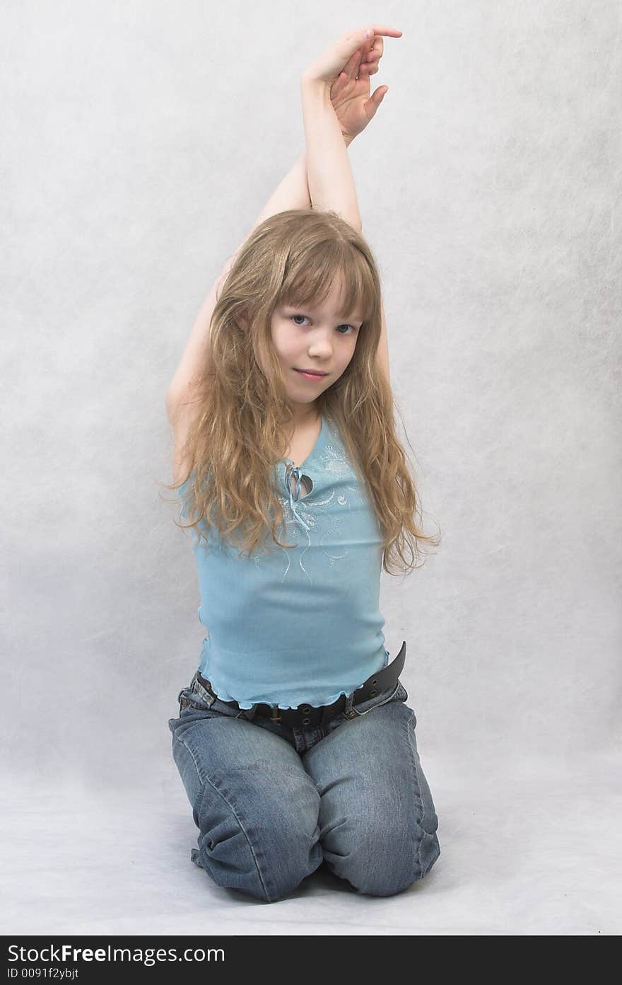 Young girl sits. She wears top and jeans. Young girl sits. She wears top and jeans.