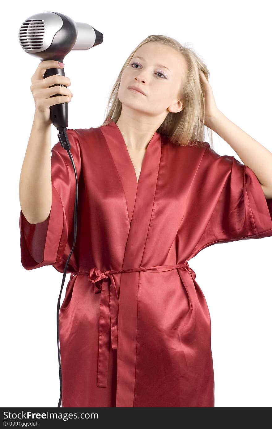 Young woman dressed red bathrobe using  hair drier