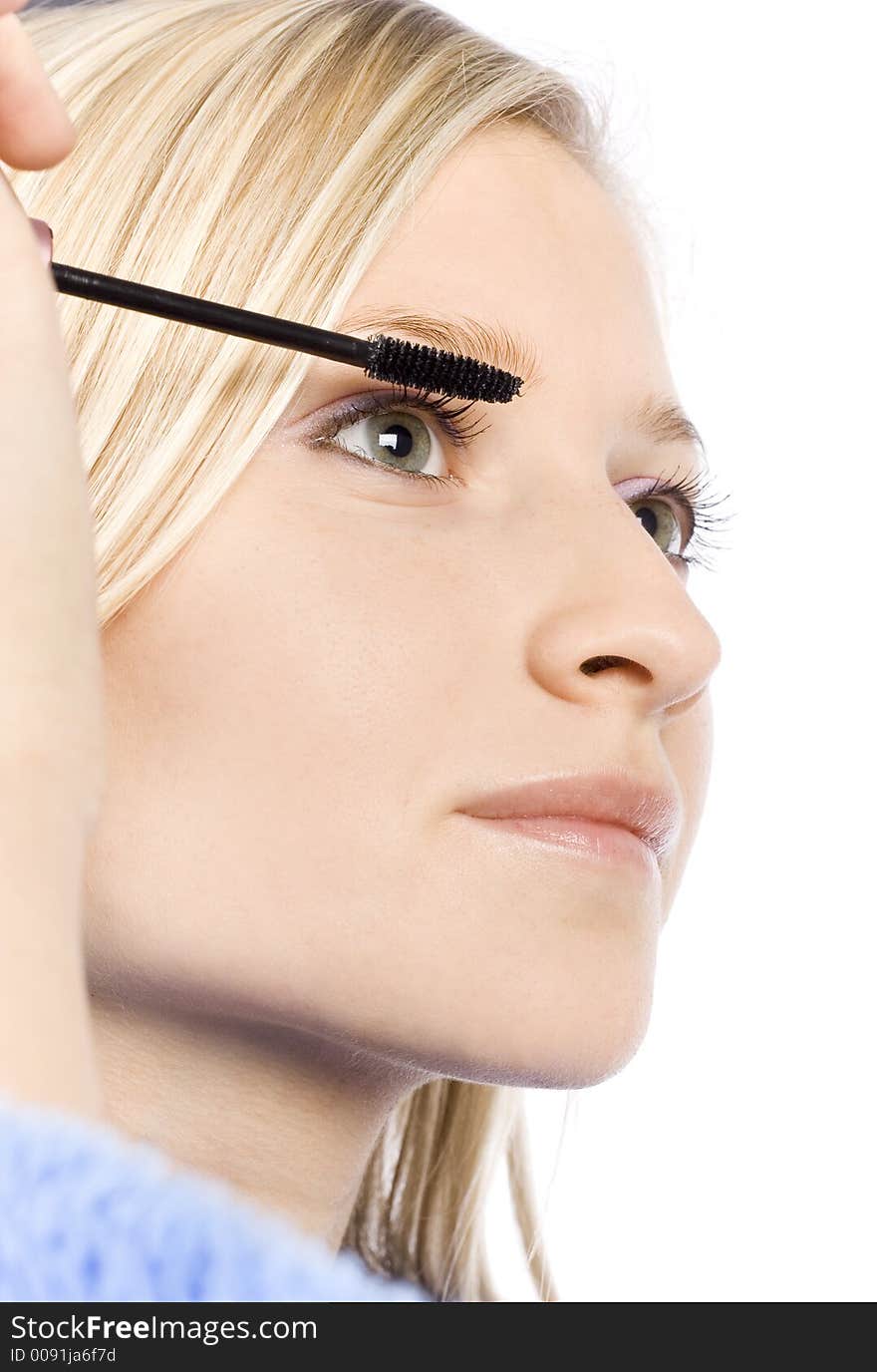 Closeup of young woman's face putting mascara (pure white background)