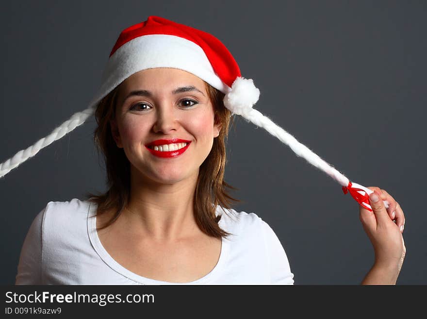 Brunette wearing a santa hat pulling on tails. Brunette wearing a santa hat pulling on tails