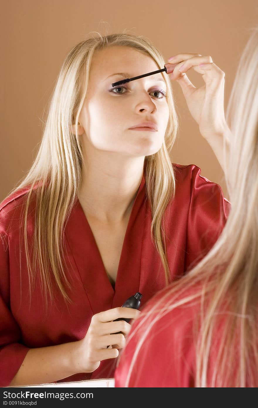 Reflexion Of Young Blone Woman Putting Mascara