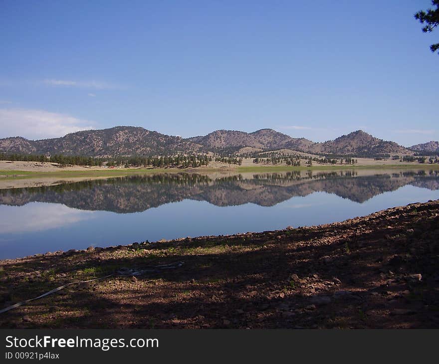 A series of hills reflected on a lake. A series of hills reflected on a lake