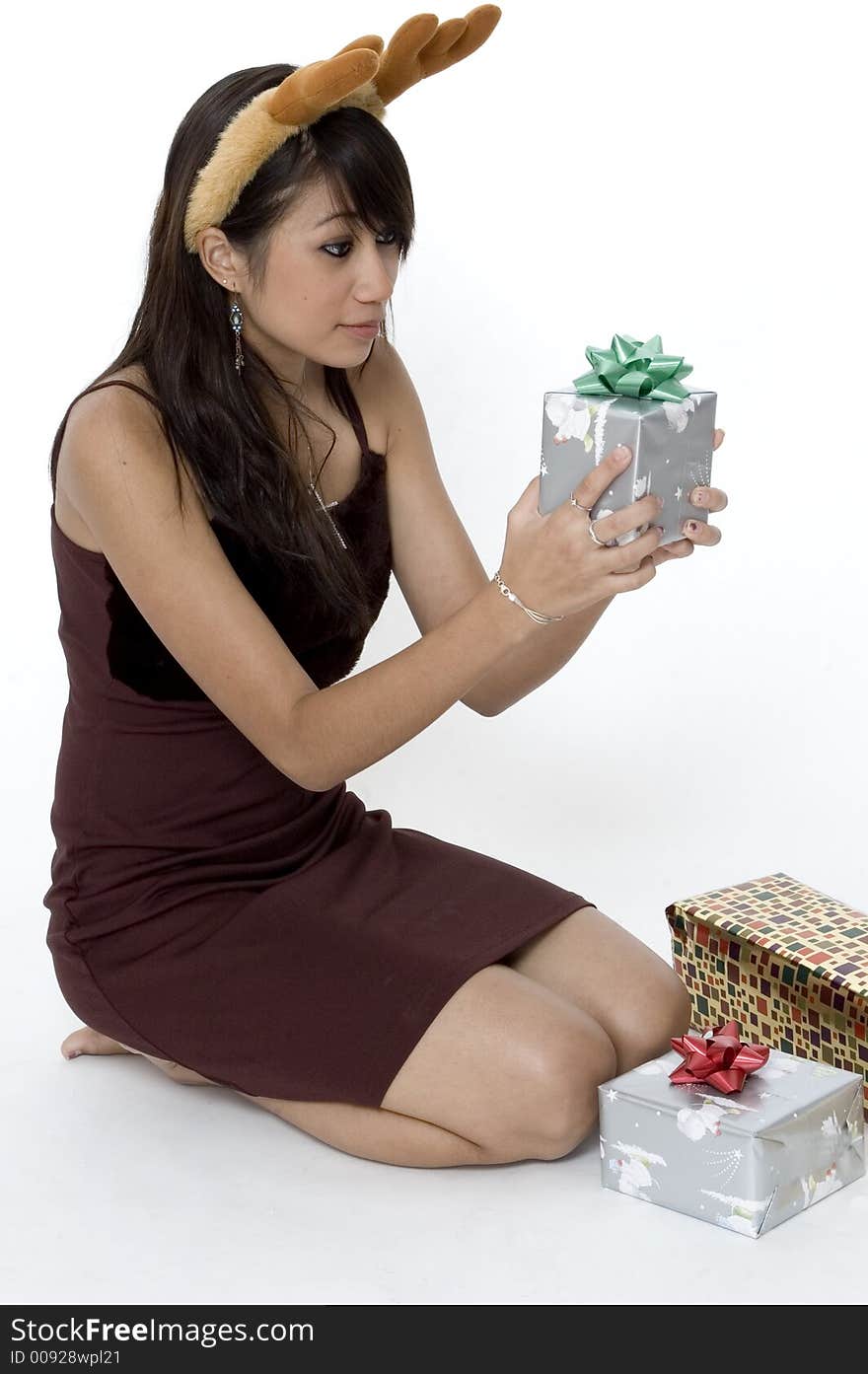 Cute Girl Sitting Next To A Pile Of Presents, Wondering Whats in Hers. Cute Girl Sitting Next To A Pile Of Presents, Wondering Whats in Hers