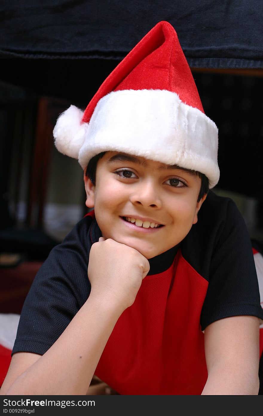 Portrait of a smiling 8 year old boy in a Santa hat. Portrait of a smiling 8 year old boy in a Santa hat