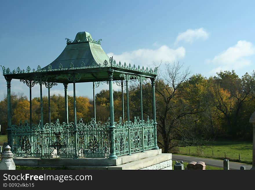 Old wrought iron gazebo overlooking meadow. Old wrought iron gazebo overlooking meadow