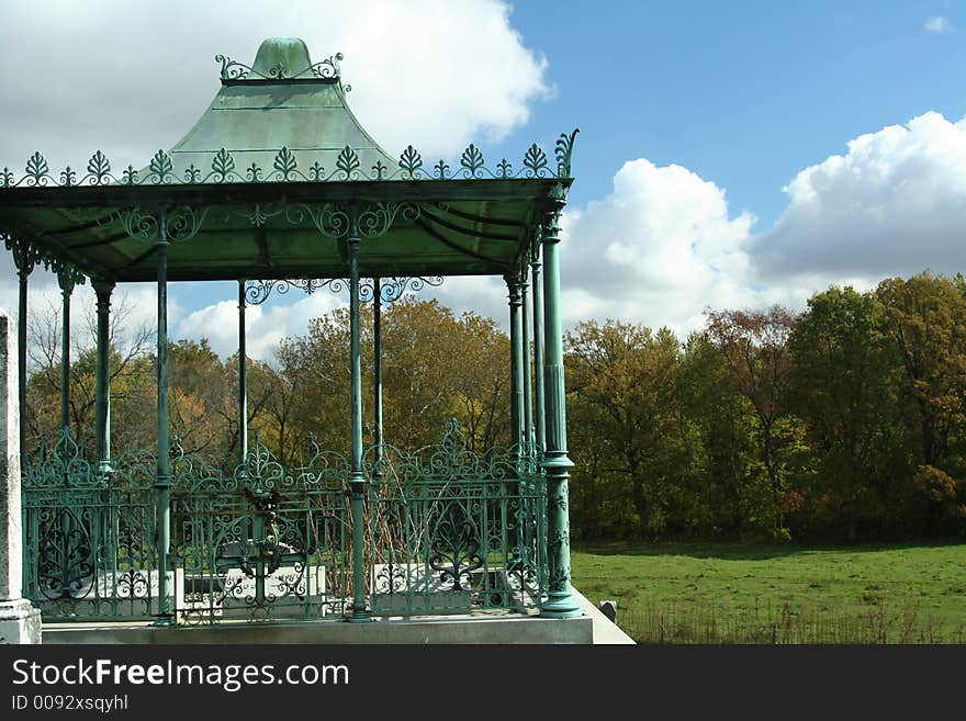 Old wrought iron gazebo overlooking meadow. Old wrought iron gazebo overlooking meadow