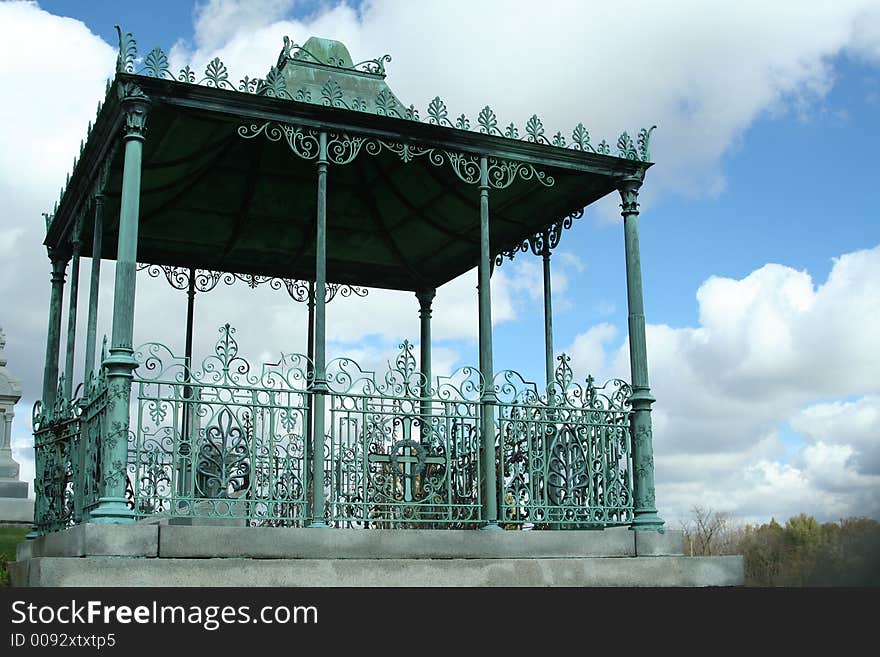 Old wrought iron gazebo overlooking meadow. Old wrought iron gazebo overlooking meadow