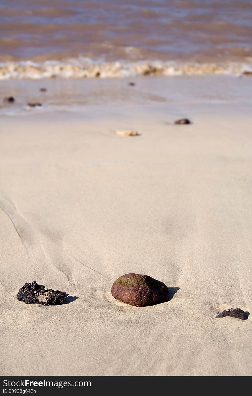 Rocks in a row on the sunny beach