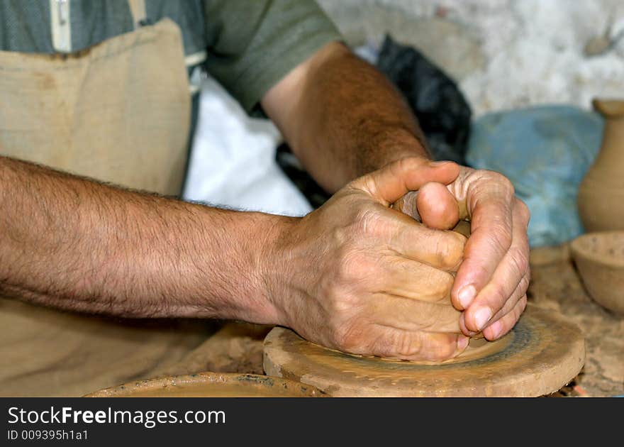 The hands of the foreman mould from clay of a product