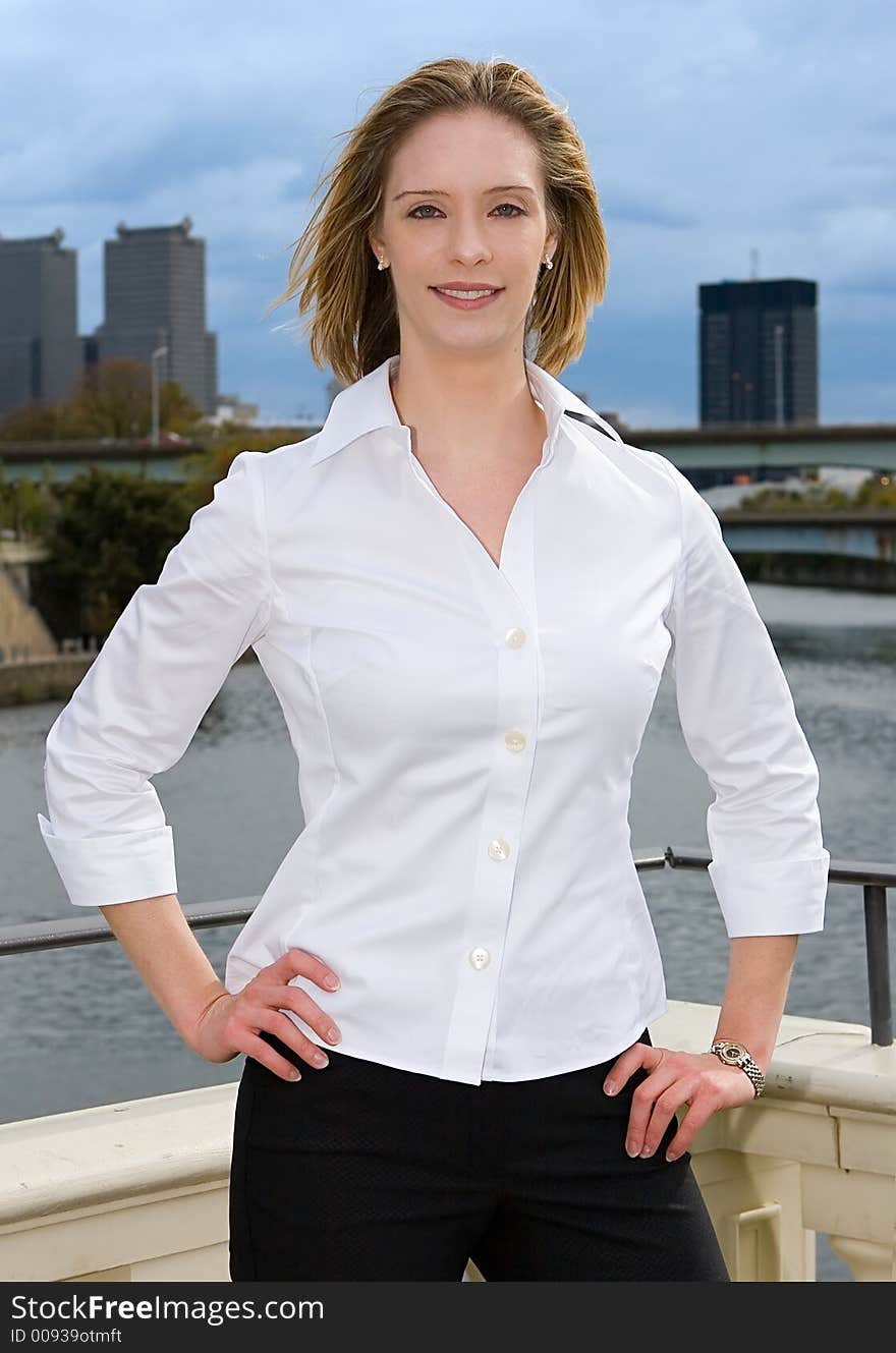 A young successful businesswomen standing confidently in front of city. A young successful businesswomen standing confidently in front of city.