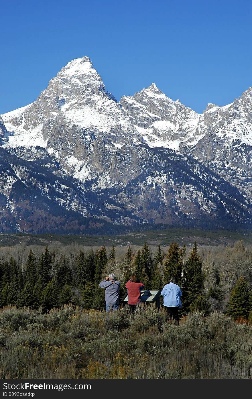 Teton mountain range with tourists looking at scene. Teton mountain range with tourists looking at scene