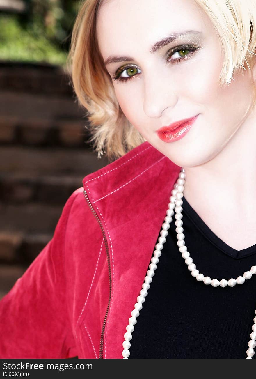 Blond business-woman with short hair in red leather jacket and pearls. Blond business-woman with short hair in red leather jacket and pearls