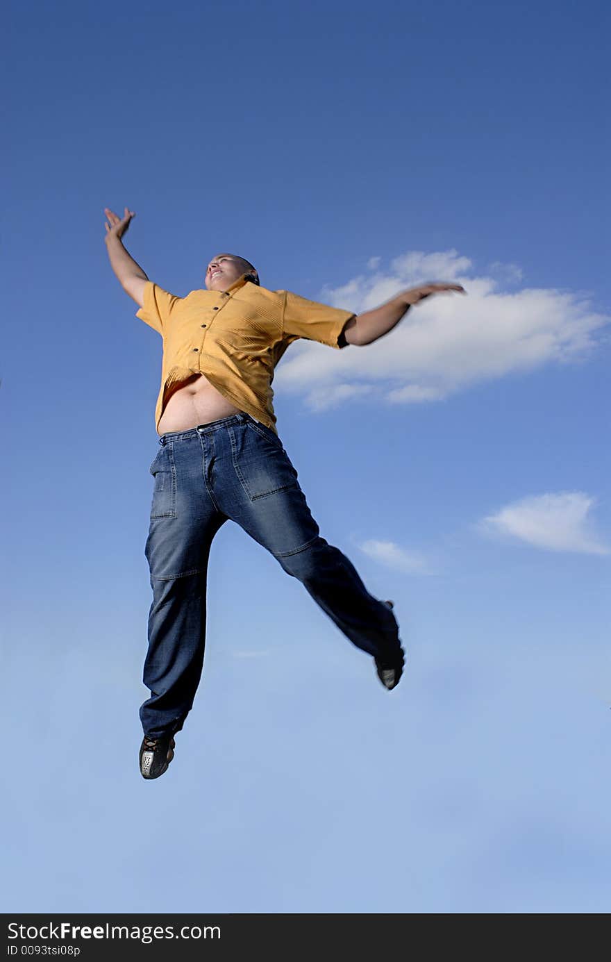 Young boy happily jumping against blue sky. Young boy happily jumping against blue sky.