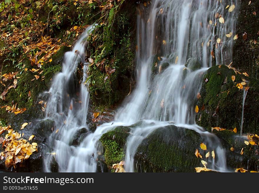 Cascade of water over moss covered rocks. Cascade of water over moss covered rocks