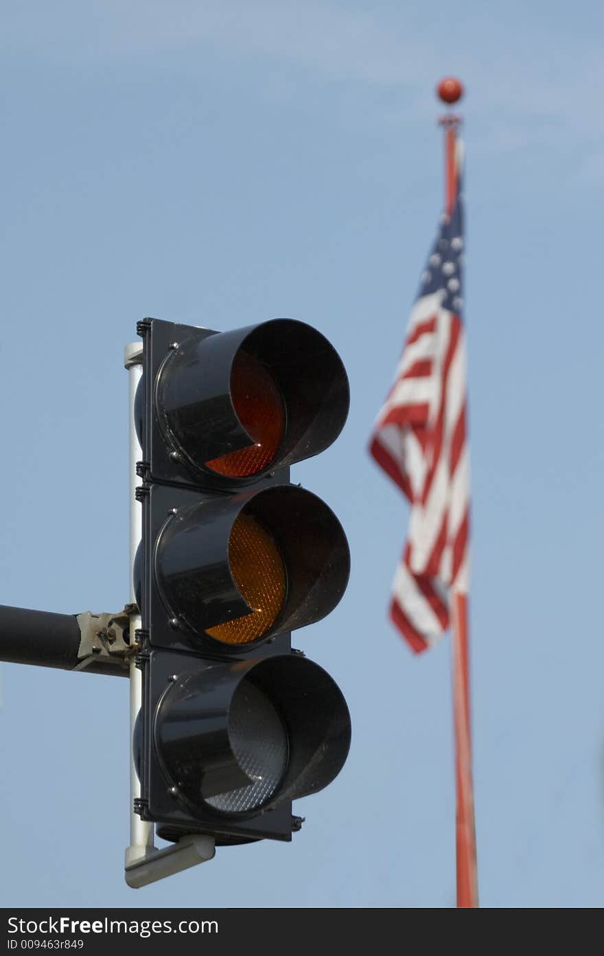 Trafic light and USA flag before blue sky