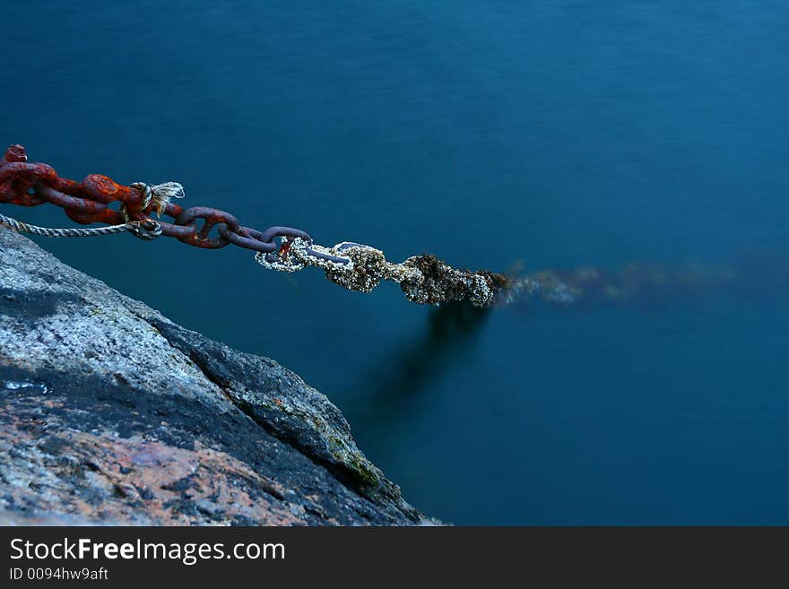 Old boat rusted chains plunging in the depths of the sea