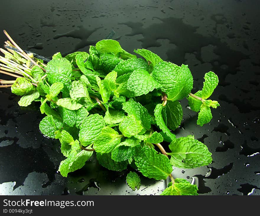 A bunch of fresh mint on black background whit drops water