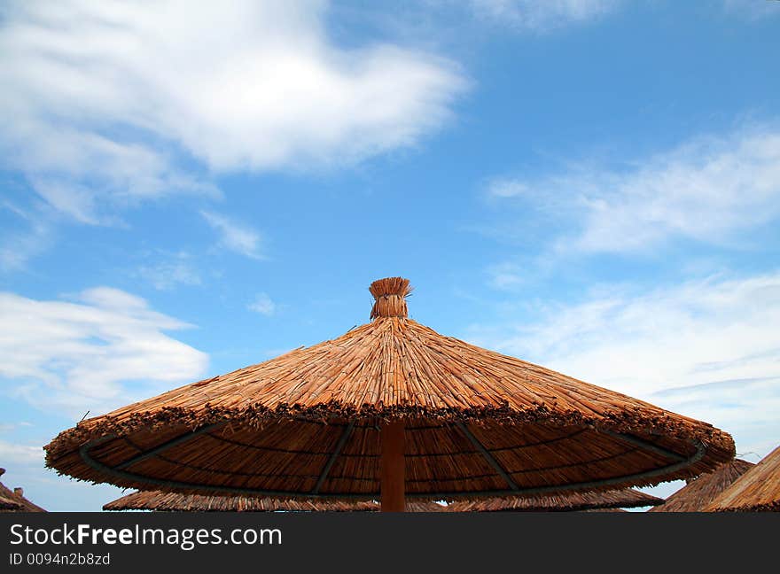 Beach umbrella blue cloudy sky. Beach umbrella blue cloudy sky