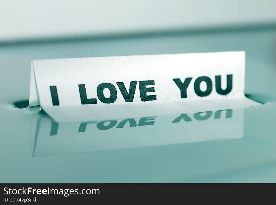 Card floating on water surface with printed word: I LOVE YOU. Card floating on water surface with printed word: I LOVE YOU