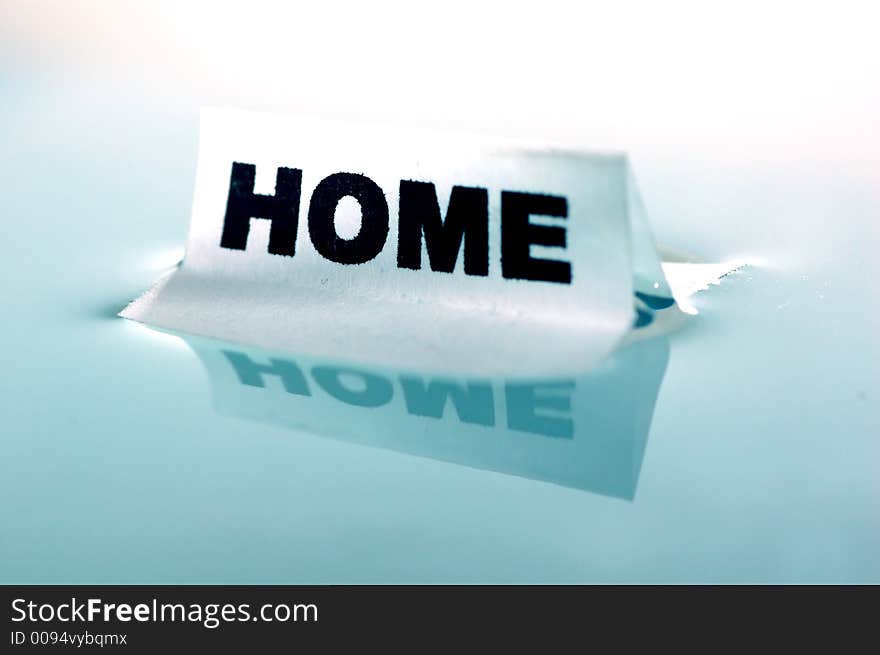 Card floating on water surface with printed word: HOME. Card floating on water surface with printed word: HOME