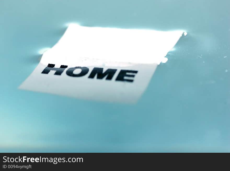 Card floating on water surface with printed word: HOME. Card floating on water surface with printed word: HOME