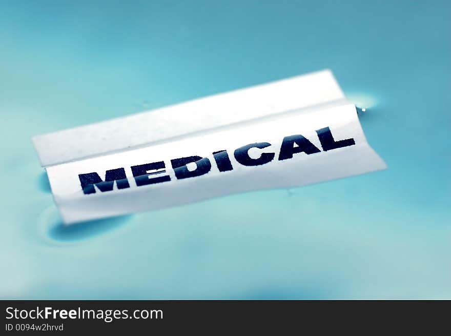 Card floating on water surface with printed word: MEDICAL. Card floating on water surface with printed word: MEDICAL