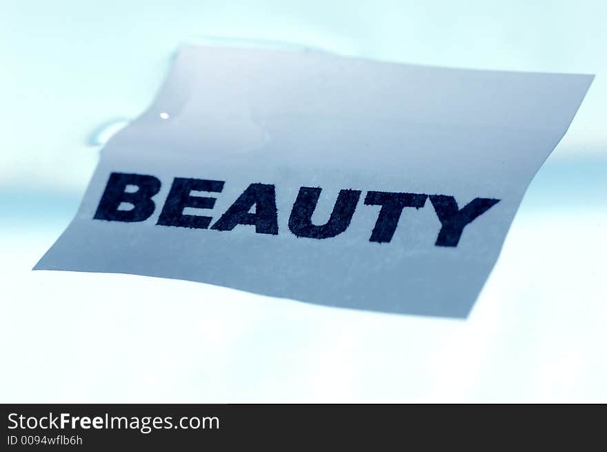 Card floating on water surface with printed word: BEAUTY. Card floating on water surface with printed word: BEAUTY