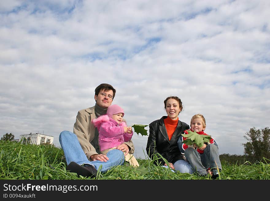 Family of four on autumn grass