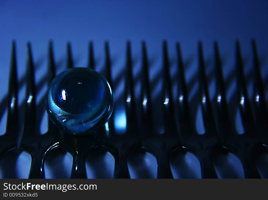 Artistic view of a glass sphere on a line of forks. Artistic view of a glass sphere on a line of forks