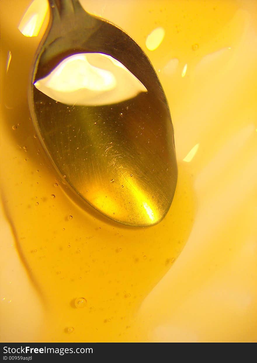 Golden honey dripping onto white plate close-up. Golden honey dripping onto white plate close-up